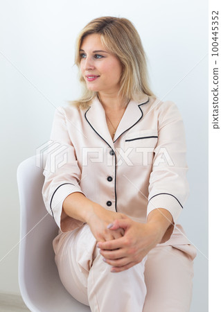 Fun minded woman wear pajama she sitting on chair use rest relax spend time in living room lounge home in own room hotel wake up 100445352