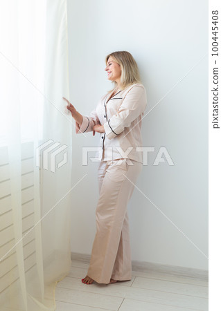 Fun minded woman wear pajama use rest relax spend time in living room lounge home in own room hotel wake up Fun minded woman wear pajama use rest relax spend time in living room lounge home in own room hotel wake up 100445408