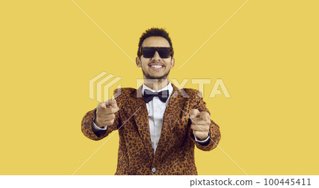 Happy black man in cool glasses and funky jacket pointing fingers at camera and smiling Happy black man in cool glasses and funky jacket pointing fingers at camera and smiling 100445411