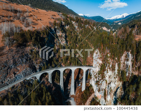 Aerial view famous mountain in Filisur, Switzerland. Landwasser Viaduct - world heritage with train Glacier express in Swiss Alps. 100445438