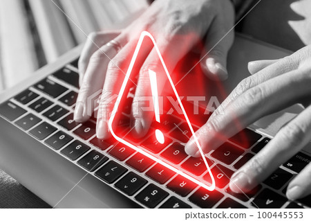 Caution concept. Neon sign over laptop. The person works at the computer. Caution concept. Neon sign over laptop. The person works at the computer. 100445553