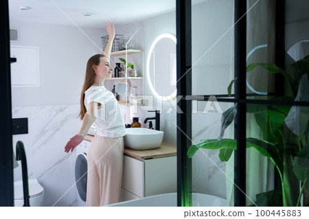 A young beauty checks her skin in front of the bathroom mirror in the morning A young beauty checks her skin in front of the bathroom mirror in the morning 100445883