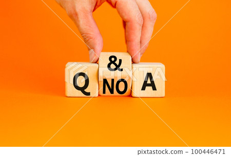Q and A question and answer symbol. Concept word Q and A or Q no A on wooden cubes. Businessman hand. Beautiful orange table orange background. Business Q and A question and answer concept. Copy space 100446471