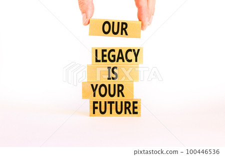 Legacy and future symbol. Concept words Our legacy is your future on wooden blocks. Beautiful white table white background. Businessman hand. Business legacy and future concept. Copy space. Legacy and future symbol. Concept words Our legacy is your future on wooden blocks. Beautiful white table white background. Businessman hand. Business legacy and future concept. Copy space. 100446536