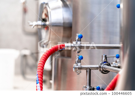 stainless steel boilers and vessels with pipes for brewing beer in a brewery 100446605