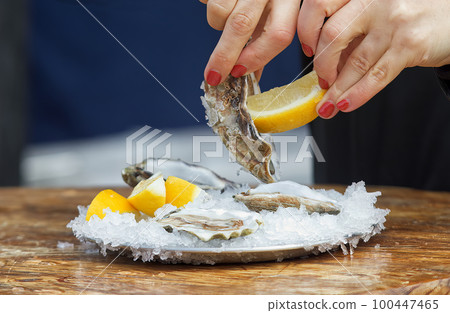 Eating oysters at a street food market. 100447465