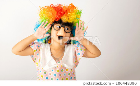 April Fool's Day. Two brothers funny kid little girl clown wears curly wig colorful big nos and glasses and mustache playing fool isolated on white background copy space, Happy child festive decor April Fool's Day. Two brothers funny kid little girl clown wears curly wig colorful big nos and glasses and mustache playing fool isolated on white background copy space, Happy child festive decor 100448390