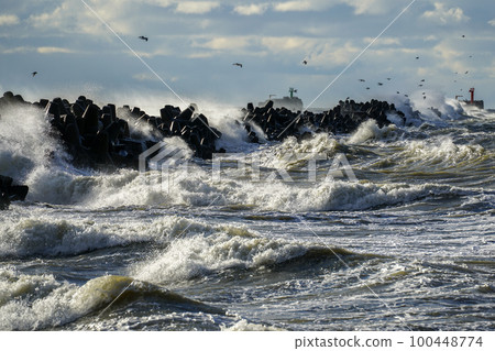 Coastal storm in the Baltic Sea, big waves crash against the harbor breakwater, breaking wave 100448774