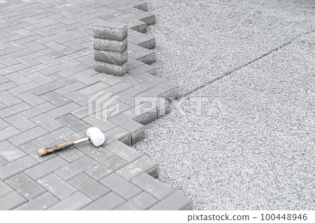 rubber hammer and lock pavers for the construction of a sidewalk 100448946