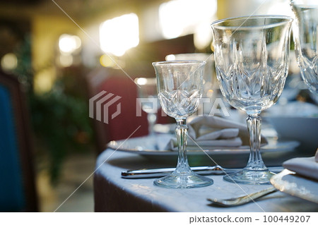 empty wine glasses on the table.table setting for a festive dinner. solar glare. empty wine glasses on the table.table setting for a festive dinner. solar glare. 100449207