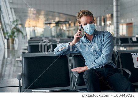 Sitting inside. Young man in formal wear is in modern airport. Conception of vacation Sitting inside. Young man in formal wear is in modern airport. Conception of vacation 100449722