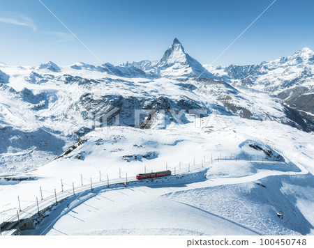 Zermatt, Switzerland -The train of Gonergratbahn running to the Gornergrat station and observatory in the famous touristic place with clear view to Matterhorn. Zermatt, Switzerland -The train of Gonergratbahn running to the Gornergrat station and observatory in the famous touristic place with clear view to Matterhorn. 100450748