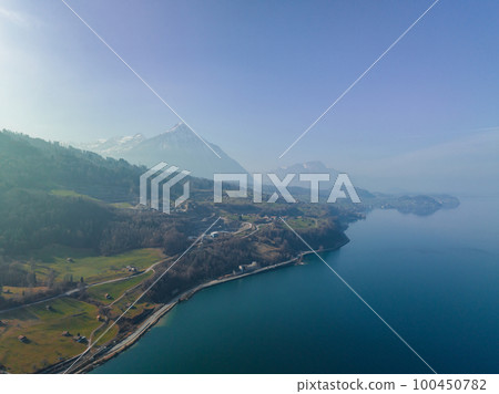 Aerial view of the snow rocky cliffs with forest by the lake. Dramatic and picturesque scene. Location place Bachalpsee in Swiss alps, Grindelwald valley, Bernese Oberland, Europe. Beauty world. Aerial view of the snow rocky cliffs with forest by the lake. Dramatic and picturesque scene. Location place Bachalpsee in Swiss alps, Grindelwald valley, Bernese Oberland, Europe. Beauty world. 100450782