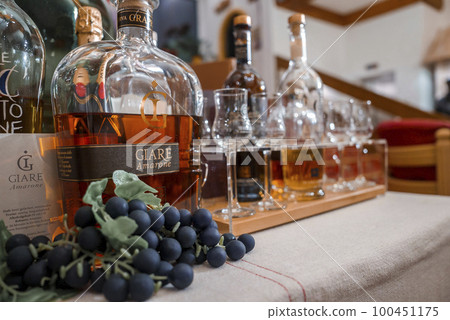 Closeup of fresh grapes with alcohol bottles and drinking glasses on table at luxurious hotel Closeup of fresh grapes with alcohol bottles and drinking glasses on table at luxurious hotel 100451175