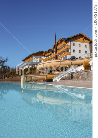 Hotel buildings reflection on calm turquoise water of swimming pool with clear blue sky in background Hotel buildings reflection on calm turquoise water of swimming pool with clear blue sky in background 100451378