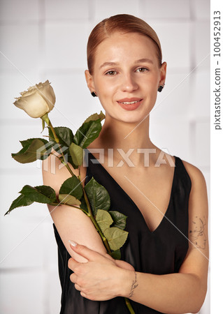 Beautiful young with special needs woman with flowers in her hand holding a flower, woman in black dress. Diversity women with disability and flowers. Beautiful young with special needs woman with flowers in her hand holding a flower, woman in black dress. Diversity women with disability and flowers. 100452913