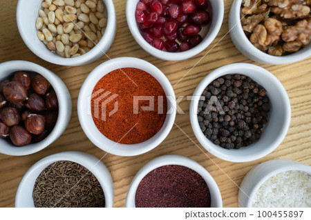 set of spices on wooden background, pomegranate, pine nut, walnut, hazelnut set of spices on wooden background, pomegranate, pine nut, walnut, hazelnut 100455897