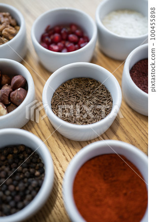set of spices on wooden background, caraway cumin, hazelnut, pine nut 100455898