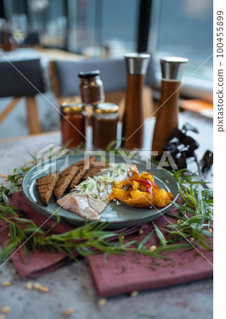 fresh marinated herring fish with potato and brown bread and onion in restaurant 100455899