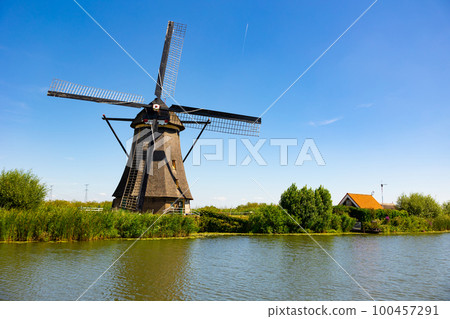 Windmills along waterside in Kinderdijk 100457291
