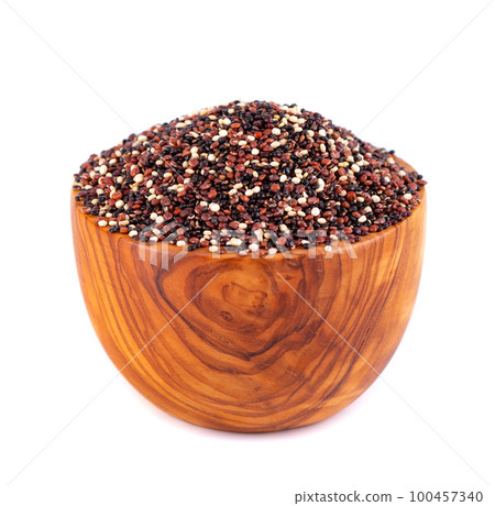 Quinoa seeds in wooden bowl, isolated on white background. Mix of white, red and black quinoa. 100457340