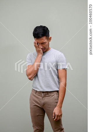 Sad and crying Asian man covering his face, feeling upset and failing, isolated background. 100460570