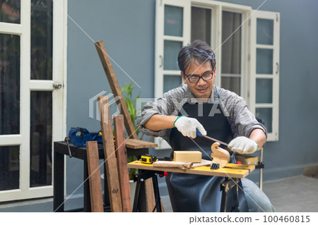 Woodworking is a hobby for male senior after retirement at home. Woodworking is a hobby for male senior after retirement at home. 100460815