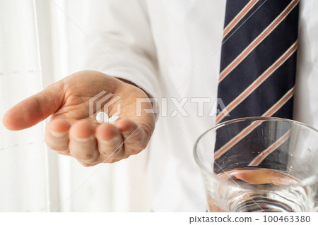 Businessman drinking medicine 100463380