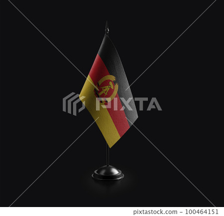 Small national flag of the DDR on a black background 100464151