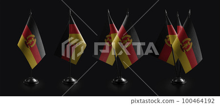 Small national flags of the DDR on a black background 100464192