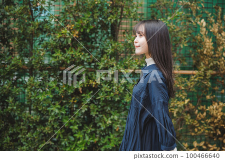 Girl walking in front of green plants Girl walking in front of green plants 100466640