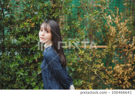 Girl walking in front of green plants Girl walking in front of green plants 100466641