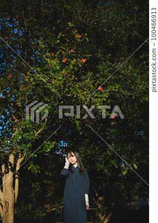 girl standing in front of camellia 100466913