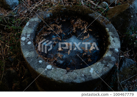 A stone basin covered with ice 100467779