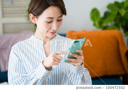 A young woman who buys and sells clothes by mail order business image A young woman who buys and sells clothes by mail order business image 100472502