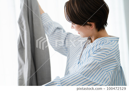 一位通過郵購買賣衣服的年輕女子商業形象 一位通過郵購買賣衣服的年輕女子商業形象 100472529