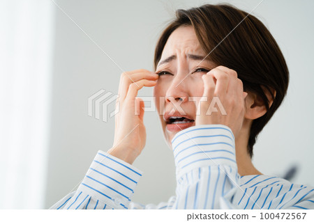 一個年輕女人抓她的眼睛花粉熱圖像 一個年輕女人抓她的眼睛花粉熱圖像 100472567