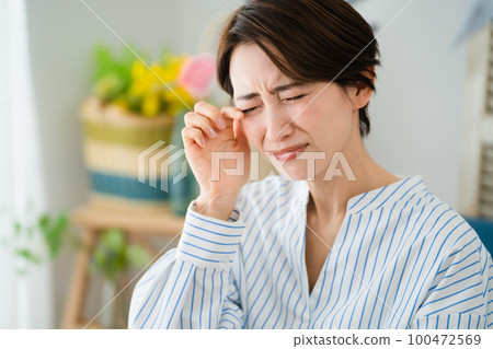 A young woman scratching her eyes Hay fever image 100472569