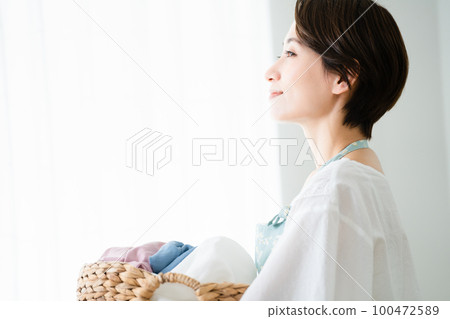 拿著洗衣籃的年輕女子生活方式形象 拿著洗衣籃的年輕女子生活方式形象 100472589