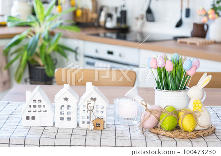 Key to house of cozy home with Easter decor with rabbit and eggs on table of kitchen. Building, design, project, moving to new house, mortgage, insurance, rent and purchase real estate Key to house of cozy home with Easter decor with rabbit and eggs on table of kitchen. Building, design, project, moving to new house, mortgage, insurance, rent and purchase real estate 100473230