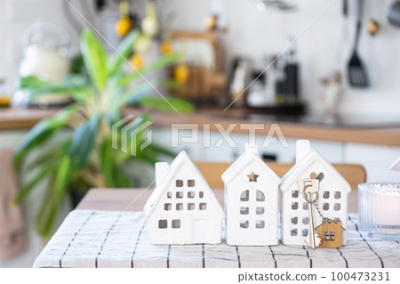 Key to house of cozy home on table of kitchen. Building, design, project, moving to new house, mortgage, insurance, rent and purchase real estate Key to house of cozy home on table of kitchen. Building, design, project, moving to new house, mortgage, insurance, rent and purchase real estate 100473231