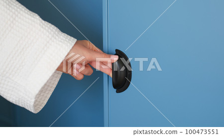 Female hand opening door of blue wardrobe at home closeup Female hand opening door of blue wardrobe at home closeup 100473551