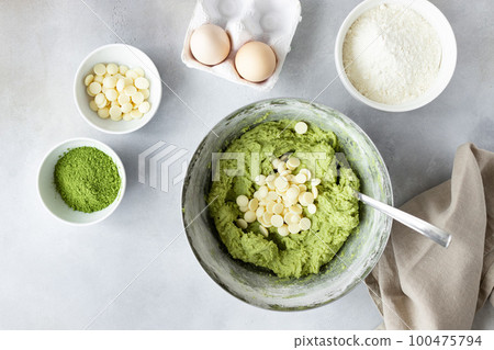 Flat lay composition with green tea matcha dough, white chocolate chips 100475794