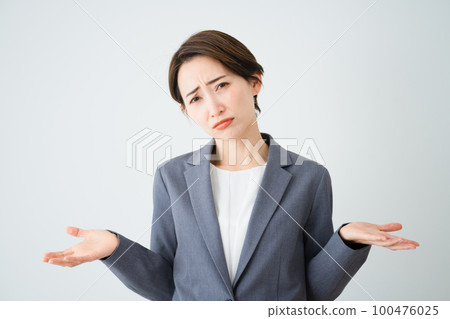 Young woman shrugging her shoulders business image Young woman shrugging her shoulders business image 100476025