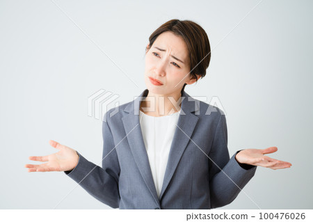 Young woman shrugging her shoulders business image Young woman shrugging her shoulders business image 100476026