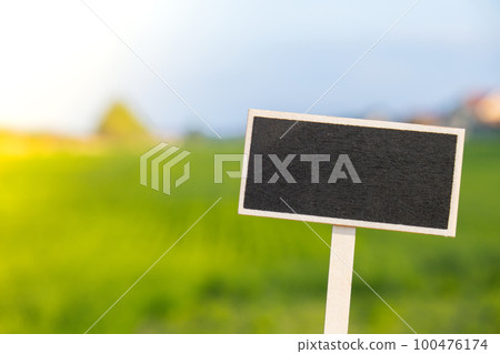 Blank Black billboard against green field landscape Empty mockup template Blackboard label at farm land. Copy space banner for your text. Agricultural landscape Summer landscape with hilly field 100476174
