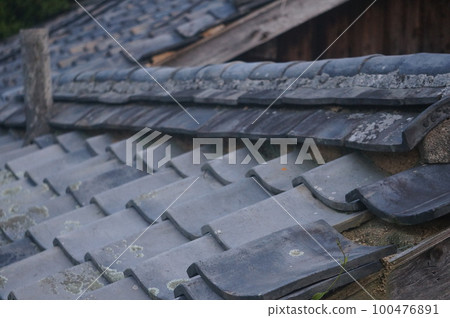 An old house with tiles that are out of place 100476891