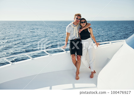 Cheerful young couple standing on the yacht on the sea. Conception of vacation 100476927