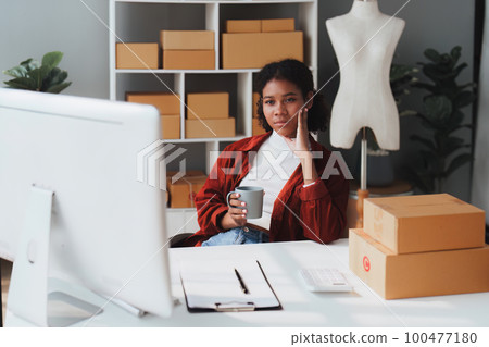 American African entrepreneur smile and working to check online order. Successful SME entrepreneur concept American African entrepreneur smile and working to check online order. Successful SME entrepreneur concept 100477180
