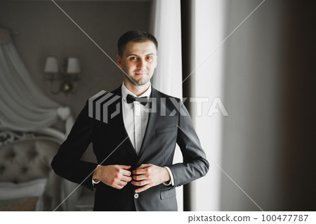 Young handsome man relaxing at his apartment in a hotel after business meeting Young handsome man relaxing at his apartment in a hotel after business meeting 100477787